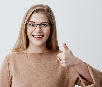 I like that. Great job. Happy young blonde female wearing casual long sleeved sweater making thumbs up sign and smiling cheerfully, showing her support and respect to someone. Body language